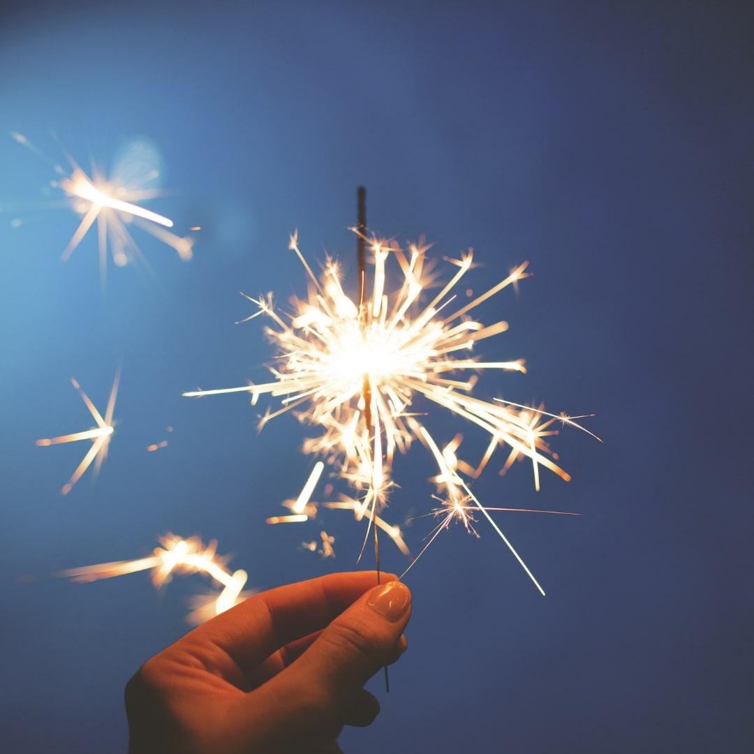 mão segurando uma vela de aniversário para festejar