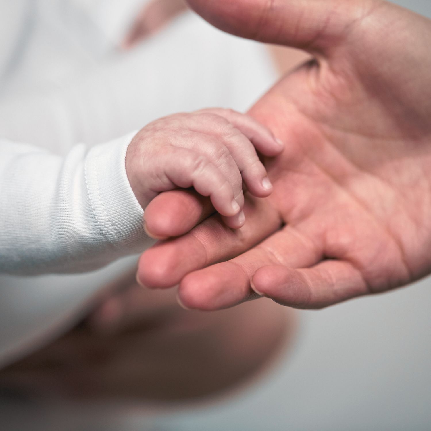 mão de bebê segurando a mão da mãe