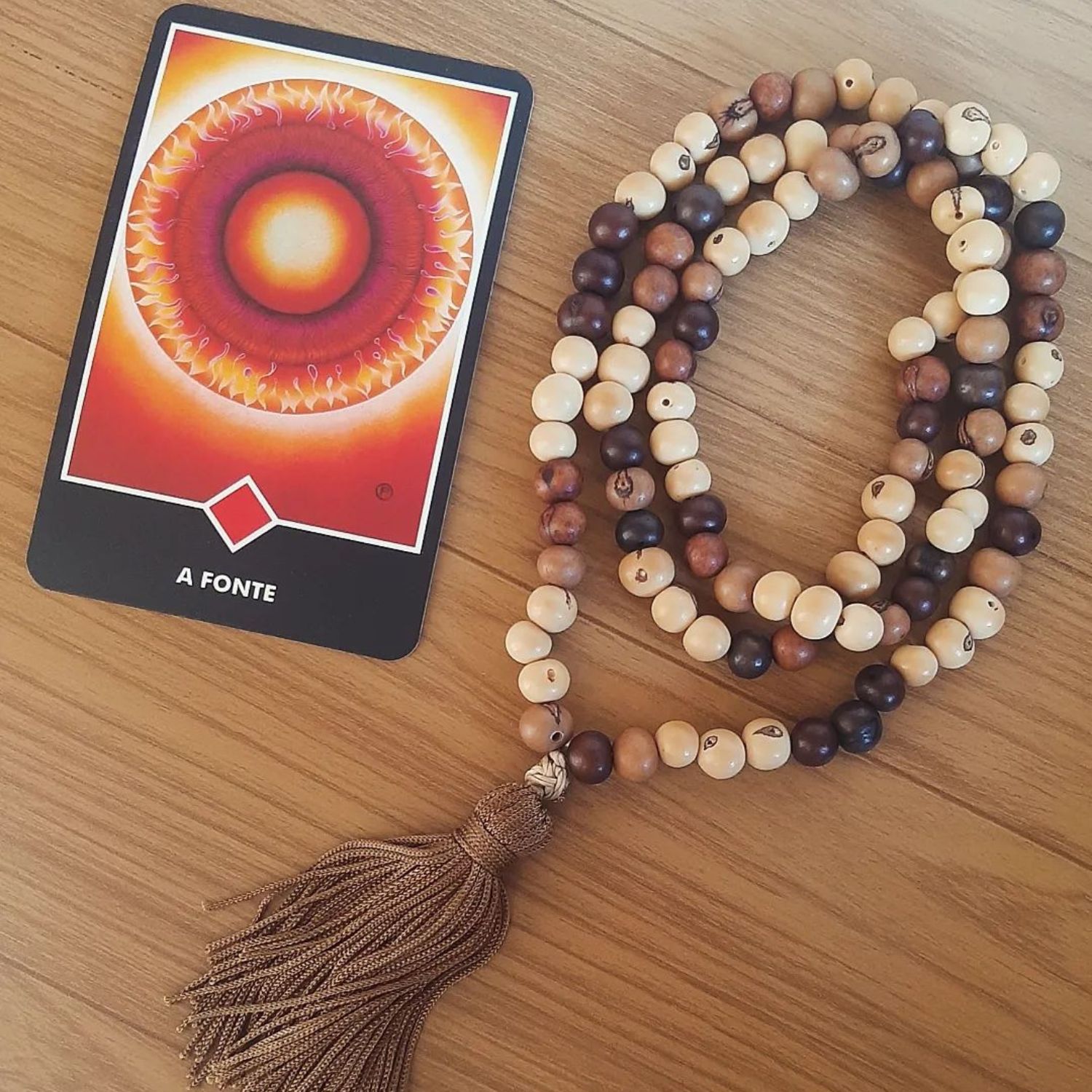 carta do Tarô Zen de Osho com um japamala bege e marrom